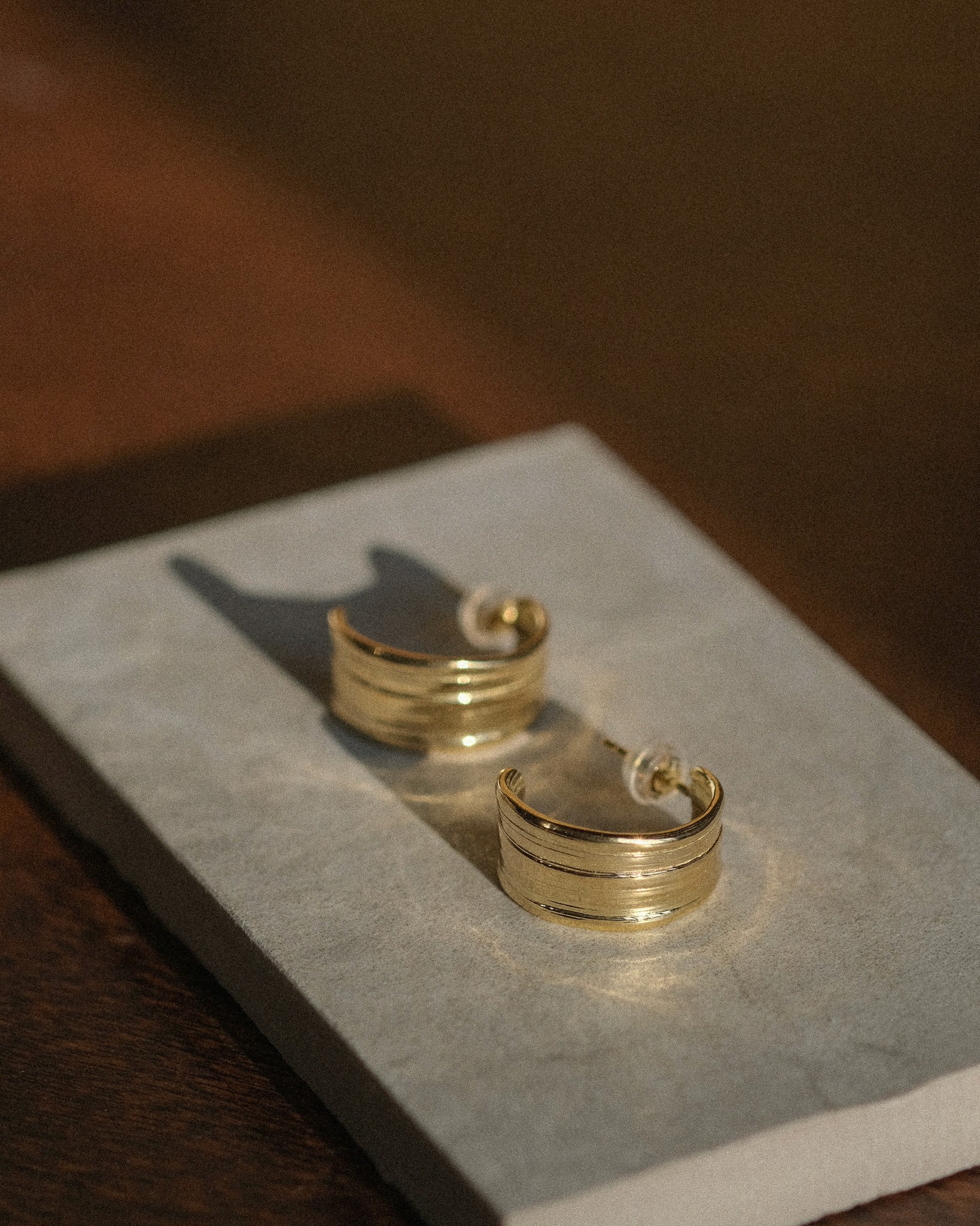 Unique large gold hoops rested on marble