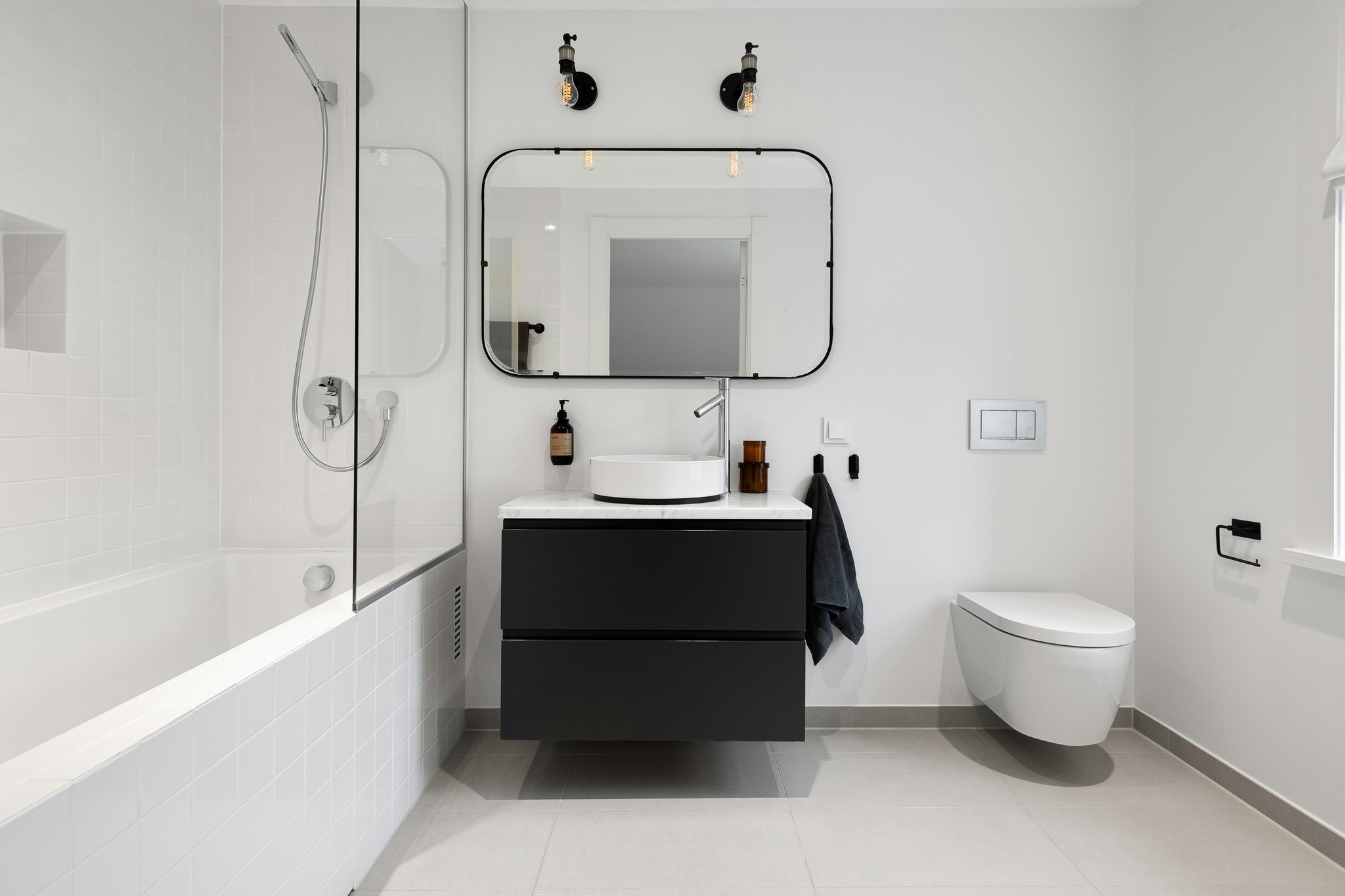 A bathroom with a toilet, sink, and mirror