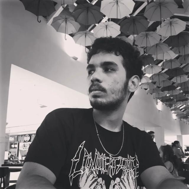 A person in a winter coat and furry hat walking along a snow-covered path through a forest of frosted trees.