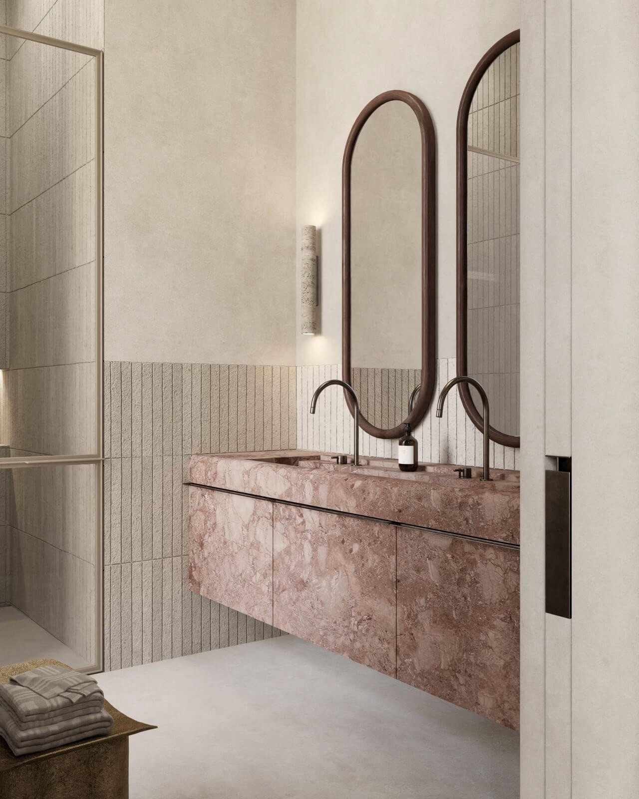 A minimalist bathroom featuring a stunning pink marble sink, dual mirrors with curved edges, and textured beige walls that create a calming aesthetic