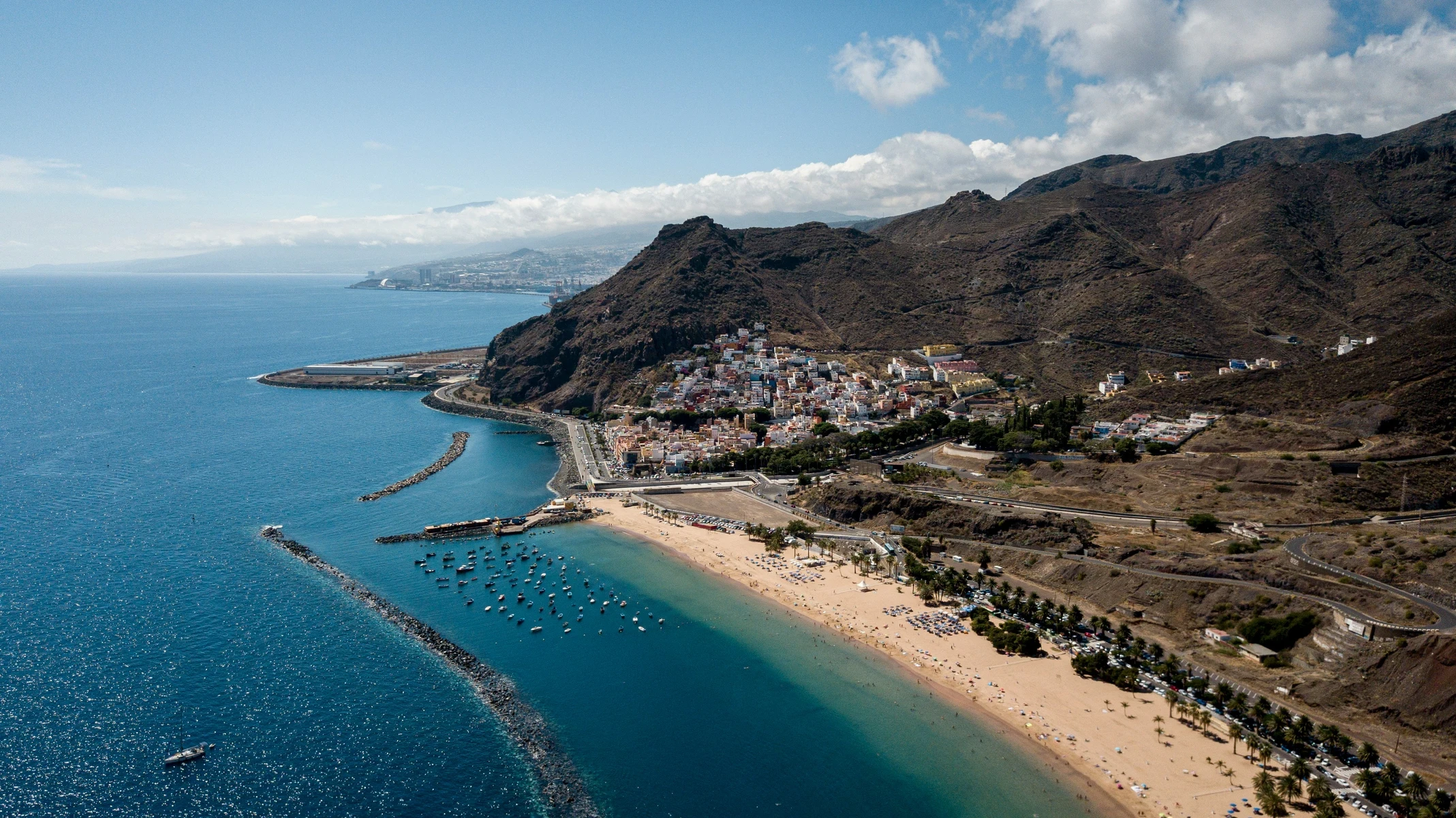 A stunning aerial view of Tenerife’s coastline, showcasing crystal-clear waters and volcanic cliffs.