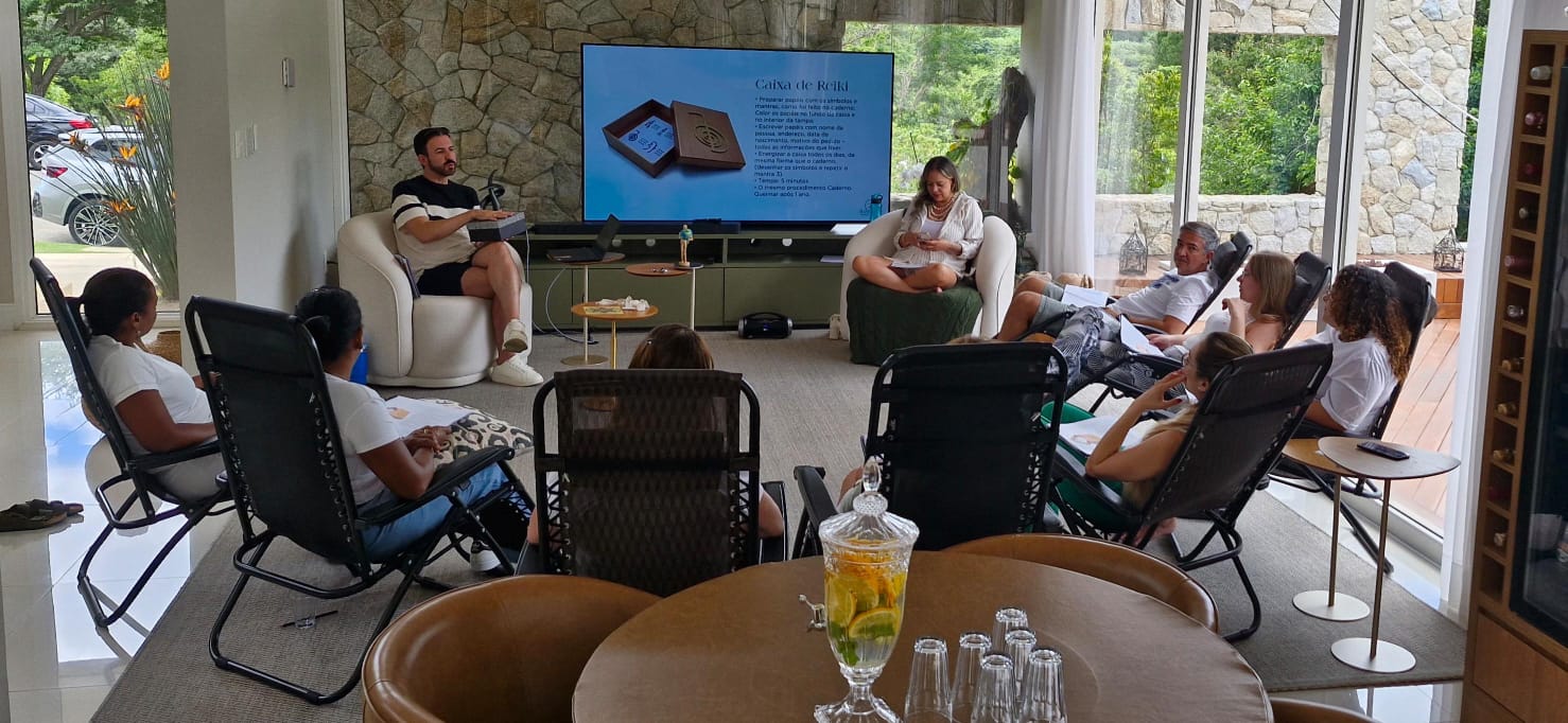 A person with curly hair sits at a desk, working on a laptop in a cozy, well-lit environment.