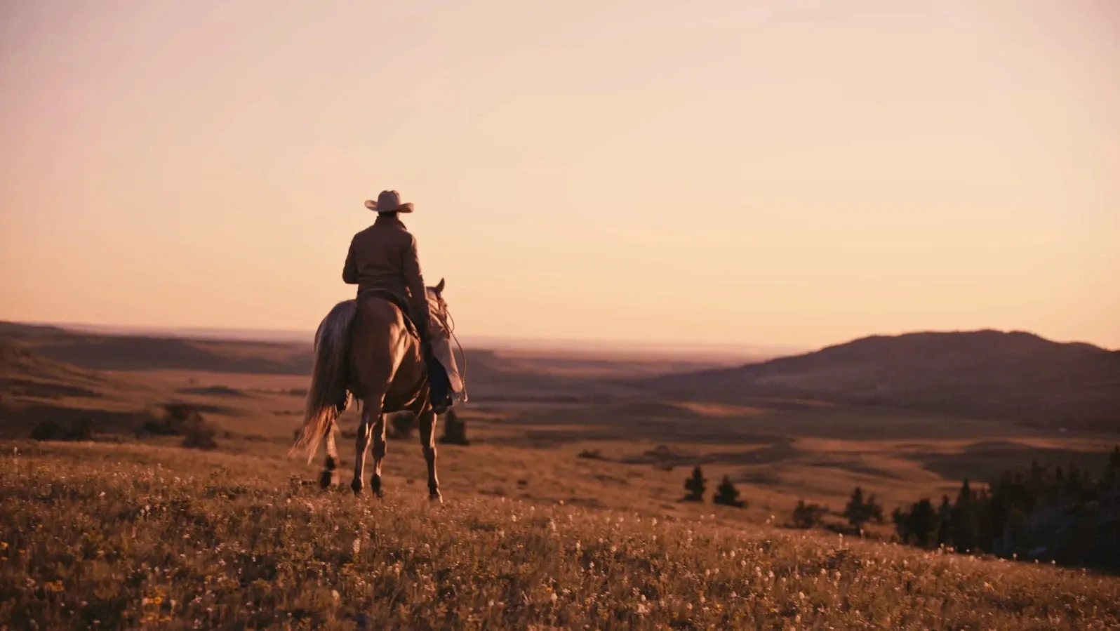 A rider crossing an open grassland at sunset, captured with the DZOFILM Arles zoom lens