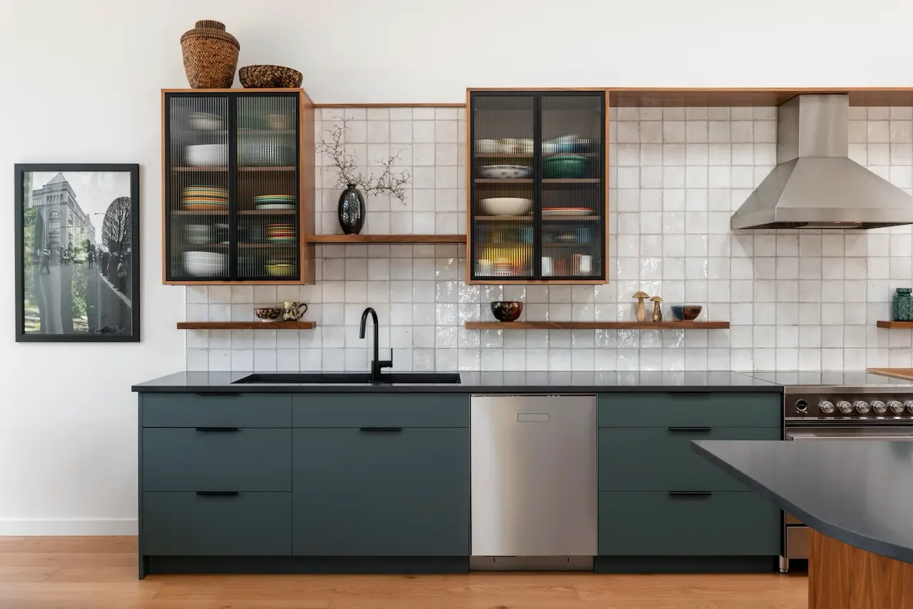 Modern two-story home with large glass windows, warmly lit interiors, and a balcony. Surrounded by trees and a manicured lawn at dusk. Cozy ambiance.