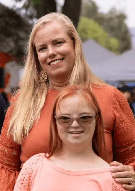 A woman and a girl posing together at an outdoor event.