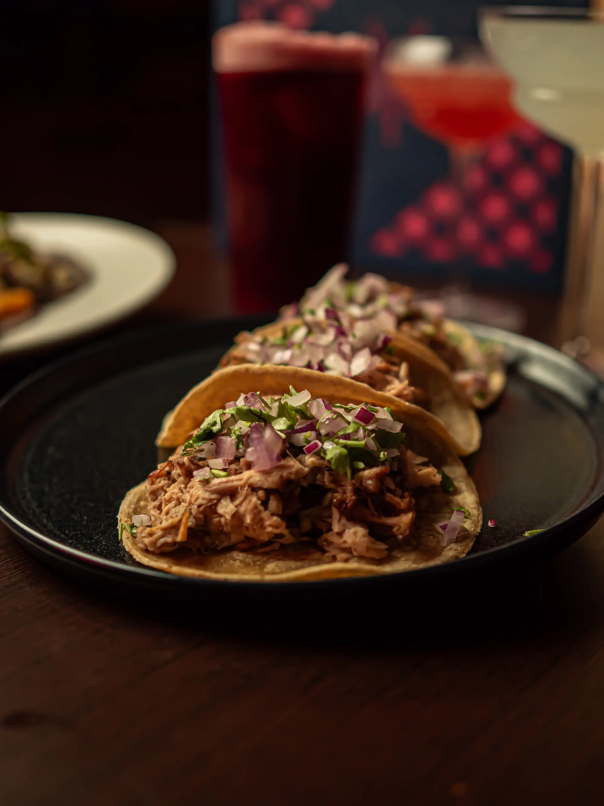 Tacos de carnitas con cebolla morada y cilantro en Piñata Cantina, restaurante mexicano en Barcelona