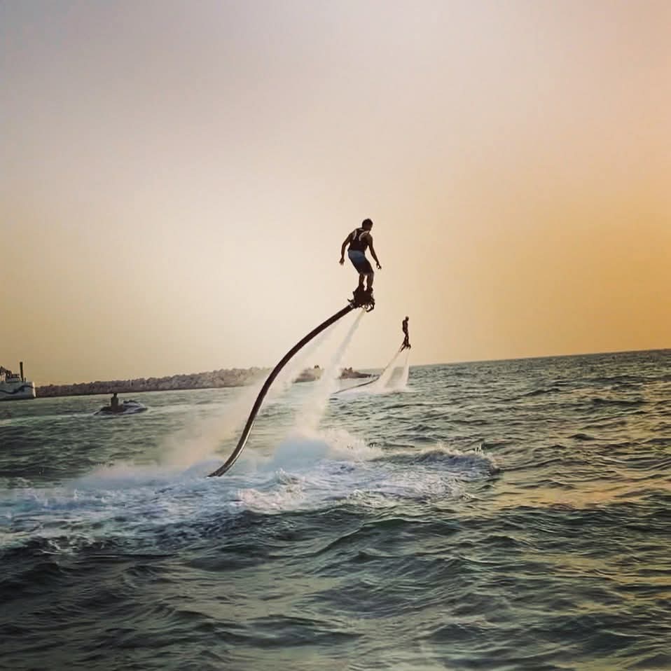 A person propels himself above the waves using a flyboard.