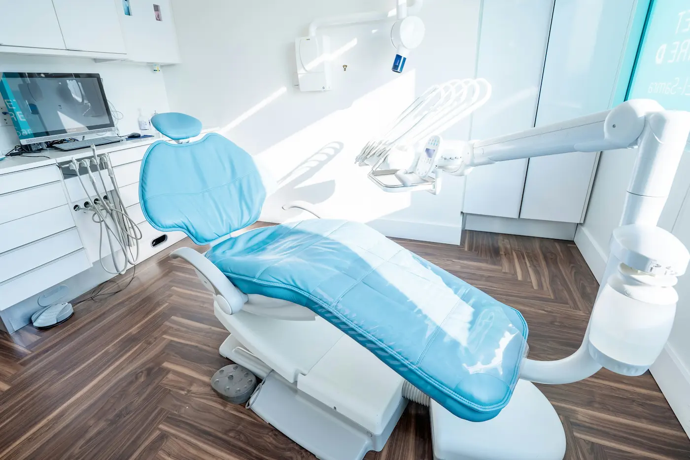 Professionally sanitized dental operatory with disinfected medical equipment, a sterile patient chair, and spotless hardwood-style flooring.