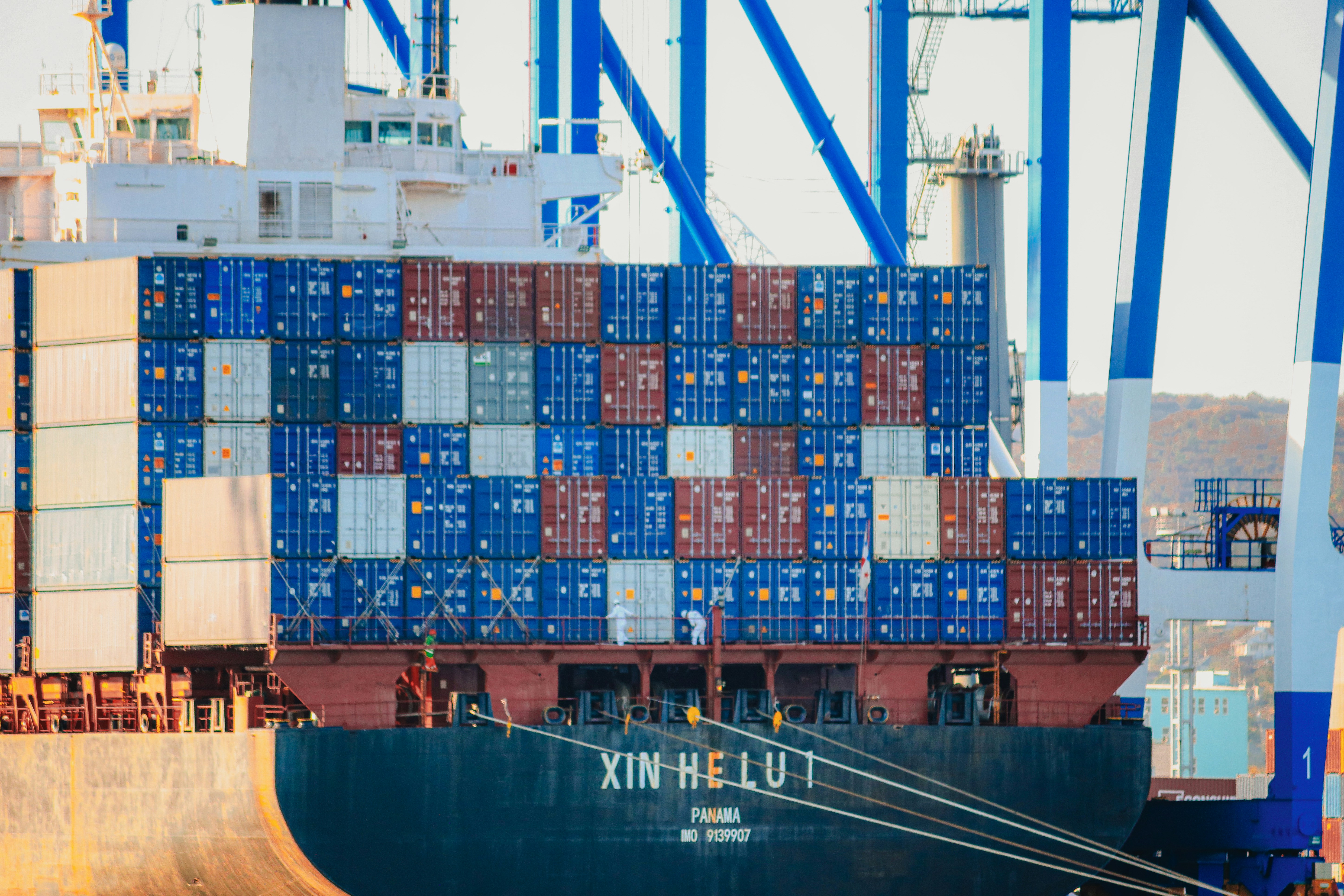 a large cargo ship in the water with a tug boat nearby