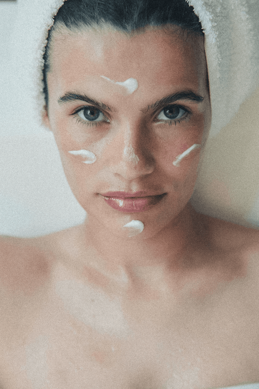 A man in a grey shirt sits in a dim office, gazing seriously at a computer screen. Blinds and office supplies create a focused and professional atmosphere.