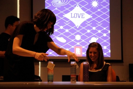 A photo of a group of people checking some painted bottles.