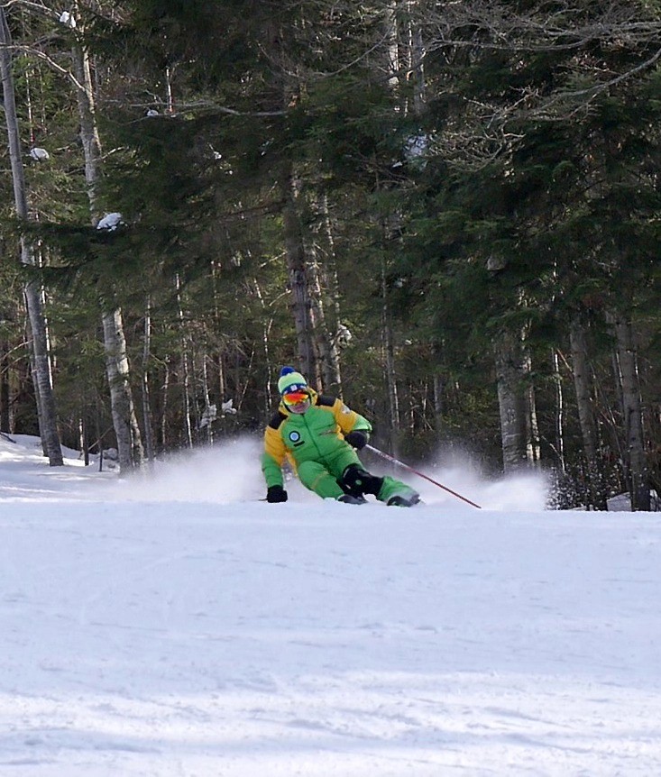 a person skiing down a snowy hill under a ski lift