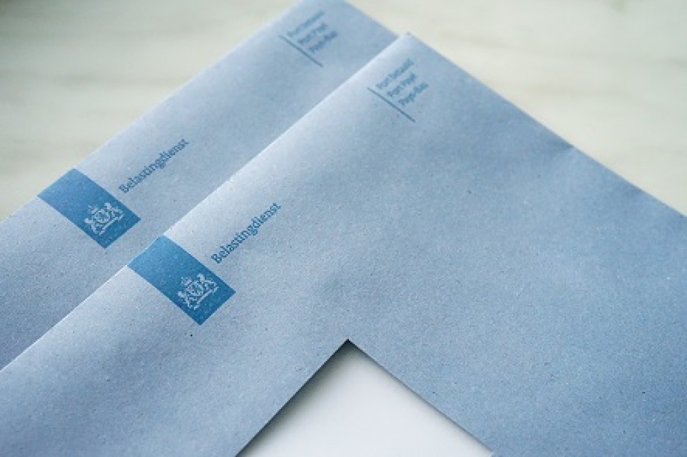 Blauwe enveloppen van de Belastingdienst, herkenbaar aan het officiële logo en gebruikelijk voor belastingaangiftes zoals btw