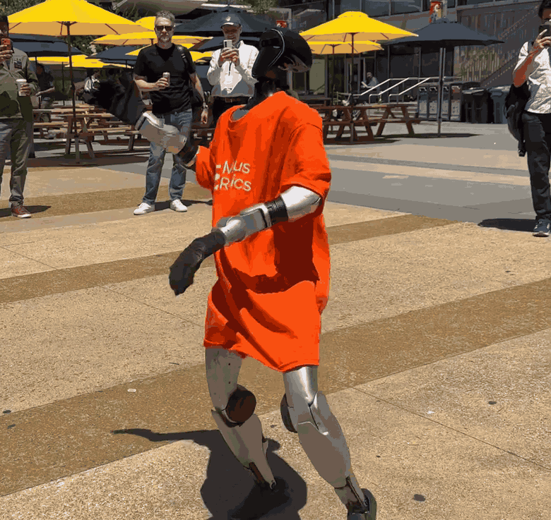 A humanoid robot dancing outside the summit -- the physical world, keeping up