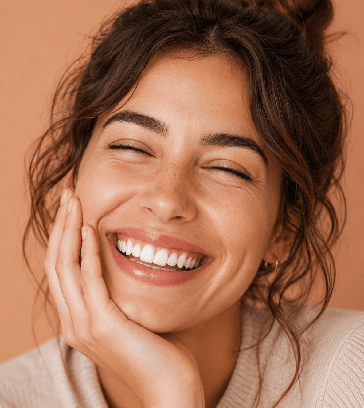 Smiling person with curly hair and closed eyes