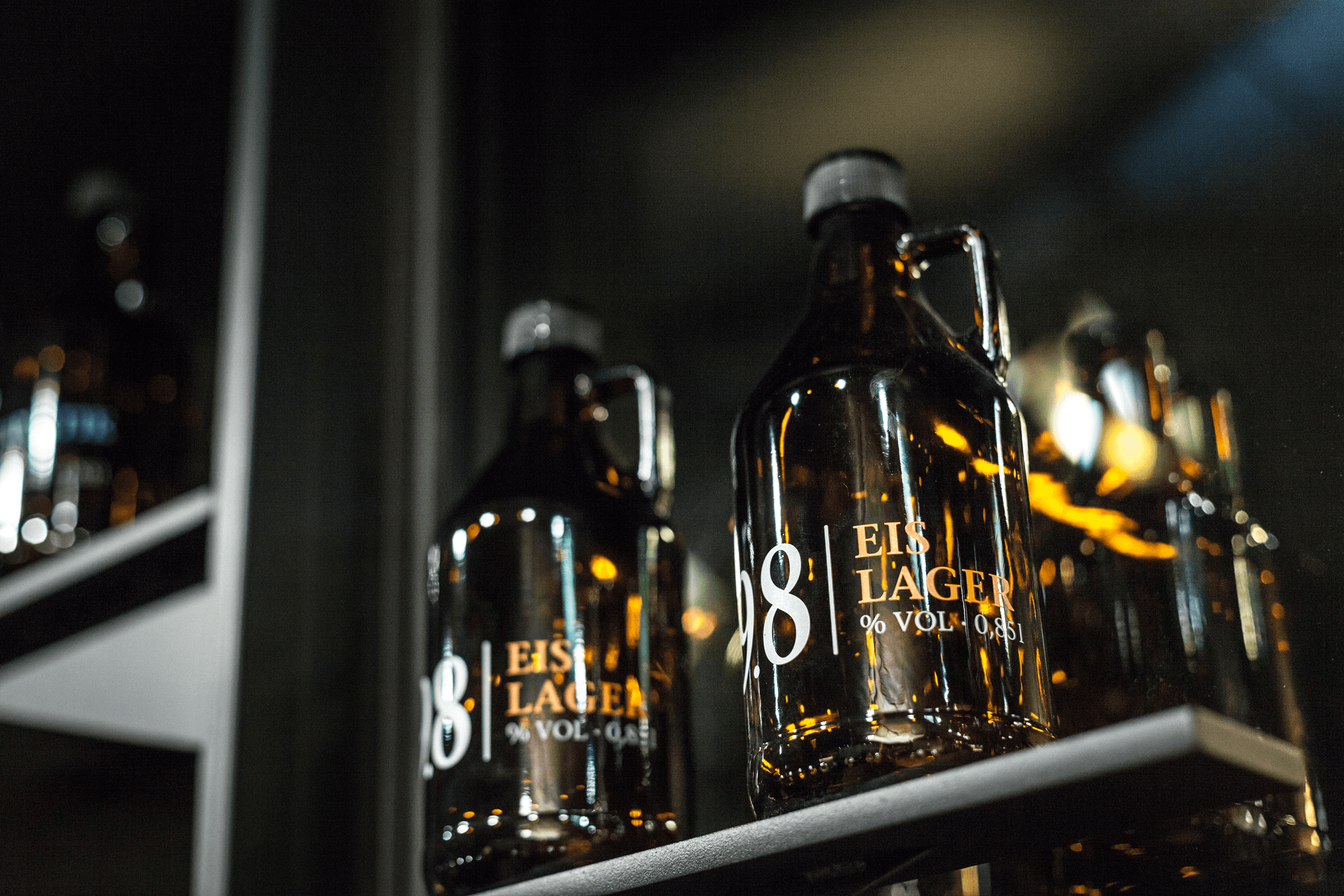 Brown growlers with "EIS LAGER" labels on shelf.