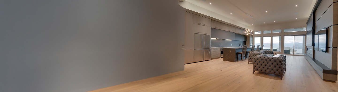 Open-concept kitchen and living space with custom cabinetry, kitchen island, and natural light, designed by J&R Custom Woodwork.