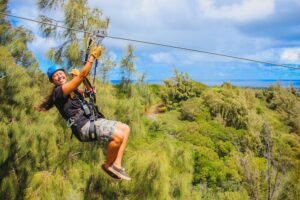A smiling woman riding one of our Oahu ziplines.