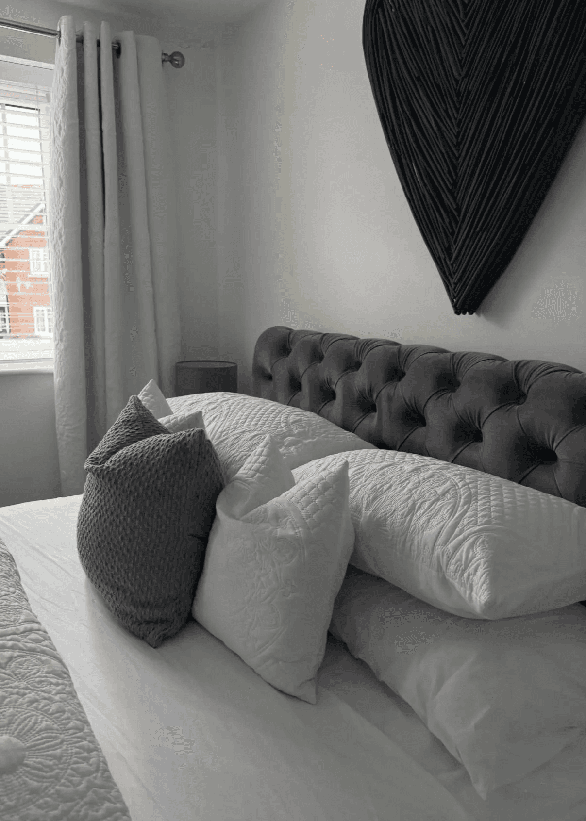 A professionally made bed with crisp white linens and perfectly arranged pillows, showcasing the fresh bed sheet and linen refresh add-on service.