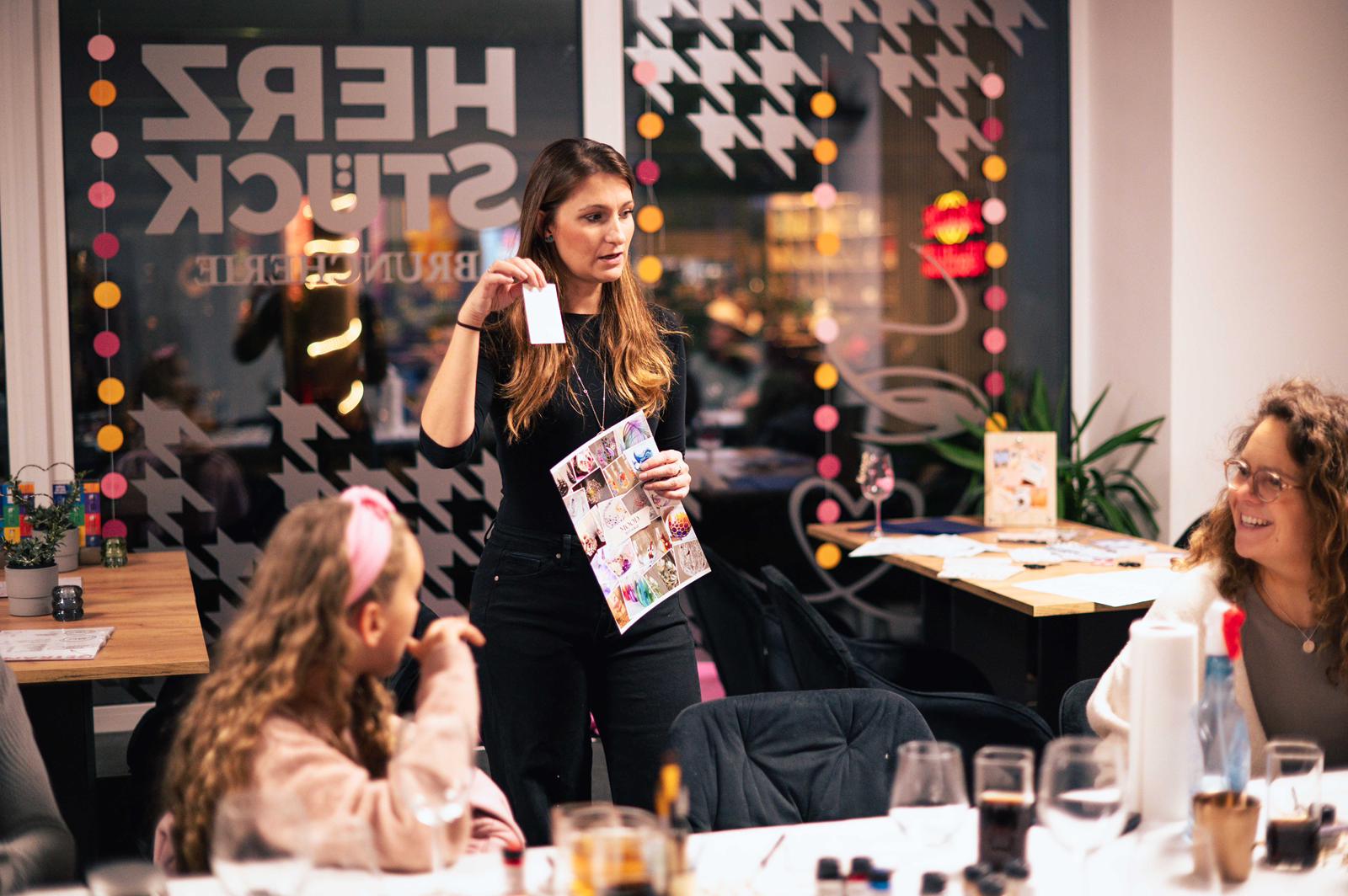 A person with short blonde hair holds a vintage camera.