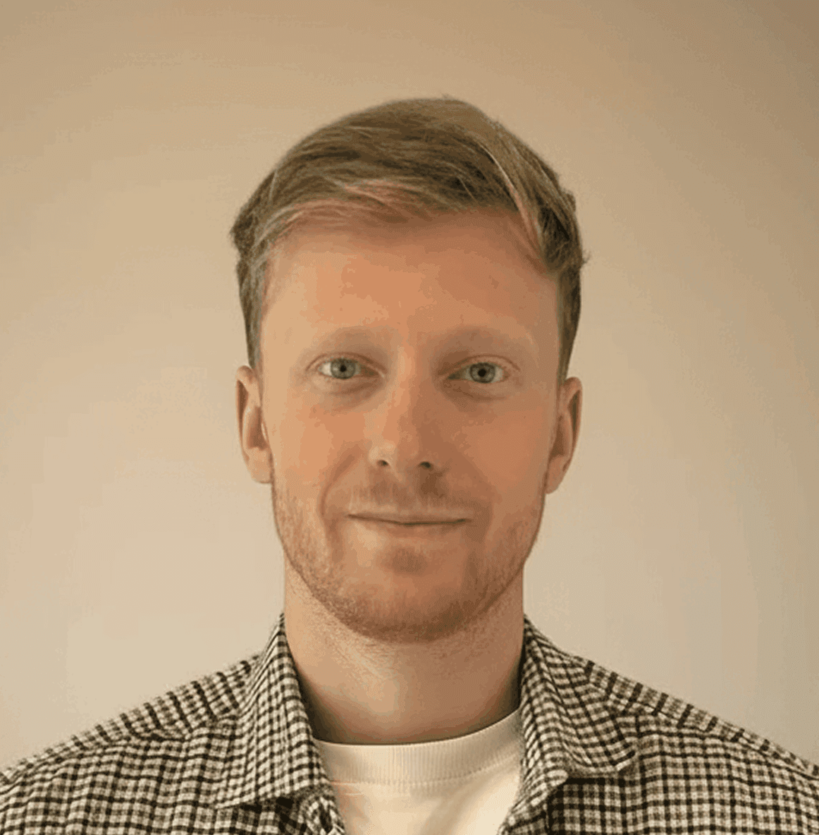 A woman with straight blonde hair wearing a light colored sweater looks away.