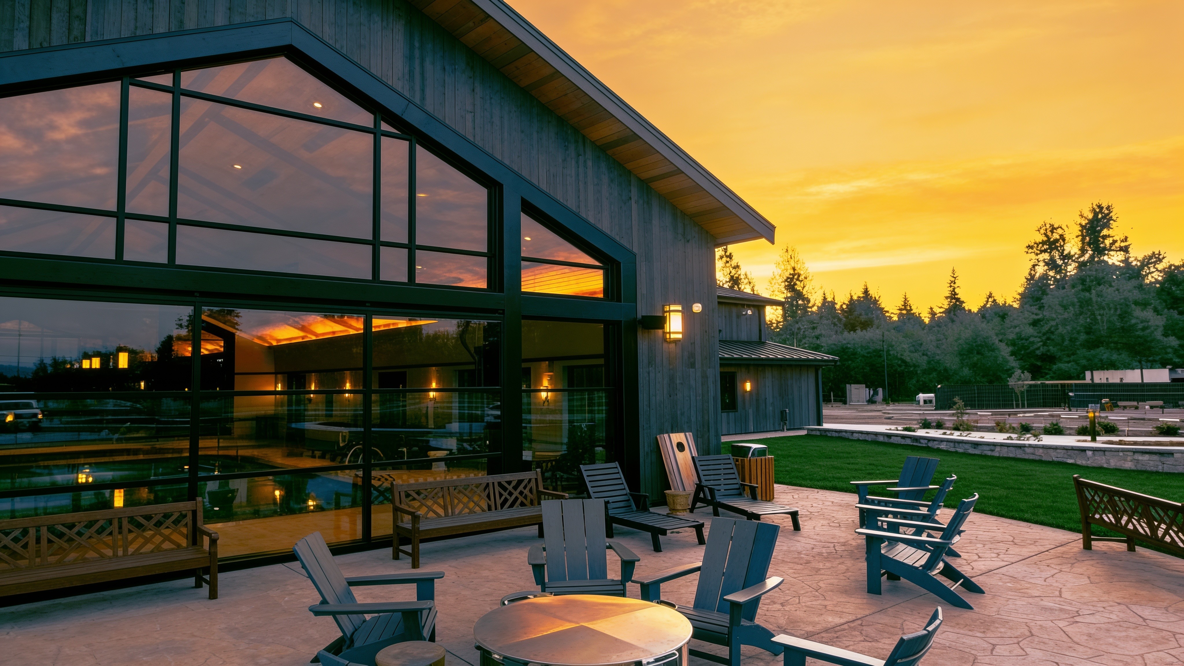 Modern resort clubhouse with a glass hydraulic door open at sunset