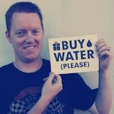 James holding a sign that says BUY WATER (please)