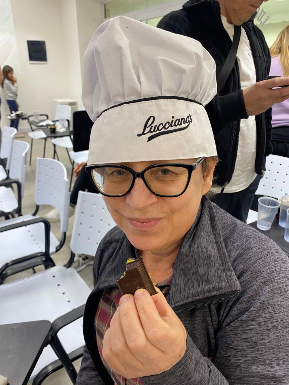 Mujer sentada sobre un tronco frente a una cascada doble en un bosque frondoso de Argentina.