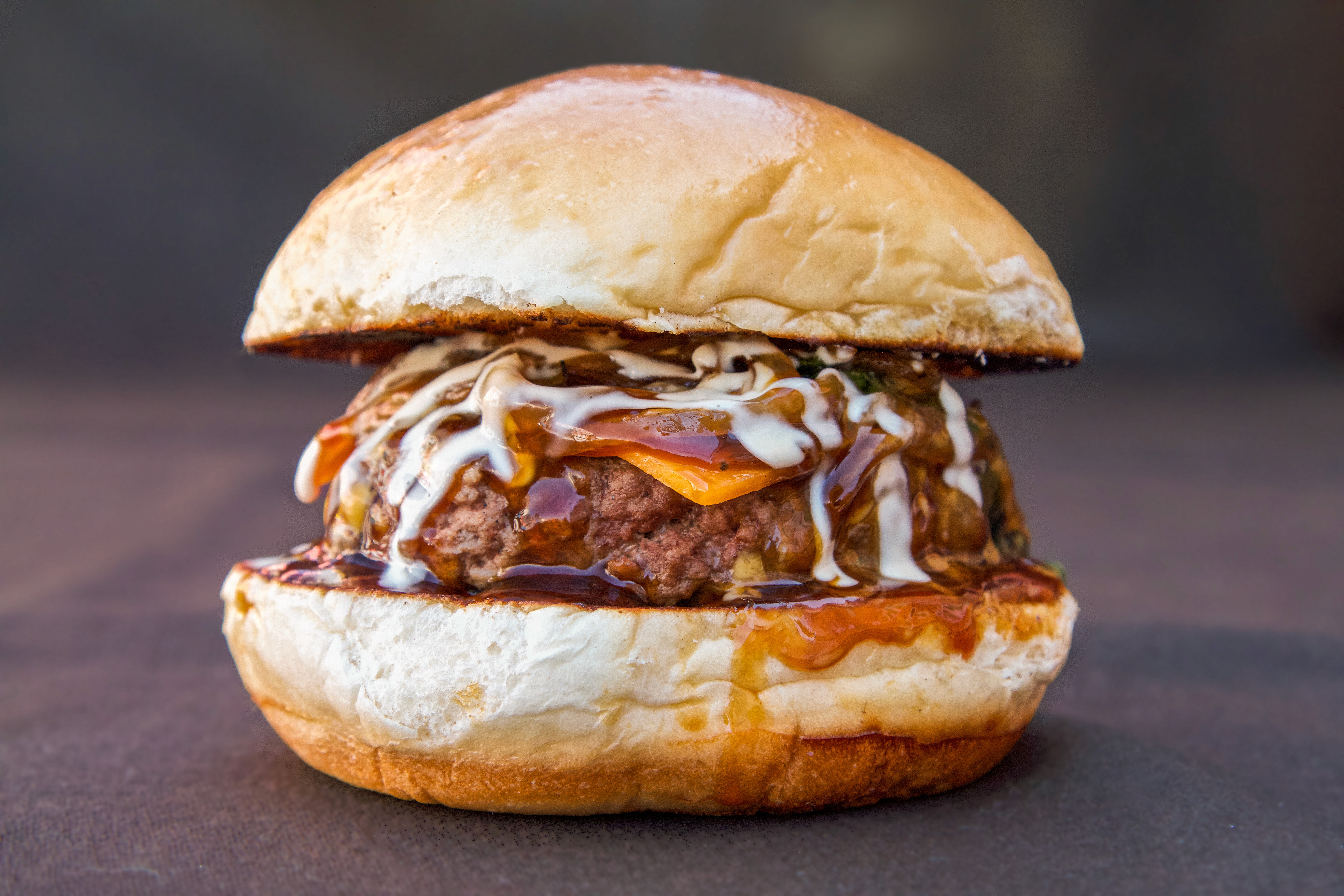 A festive platter of roasted vegetables, including sliced, seared pears or apples and charred tomatoes, garnished with walnuts and rosemary sprigs, set next to a pumpkin, a glass of red wine, and lit candles for a holiday or autumn meal.