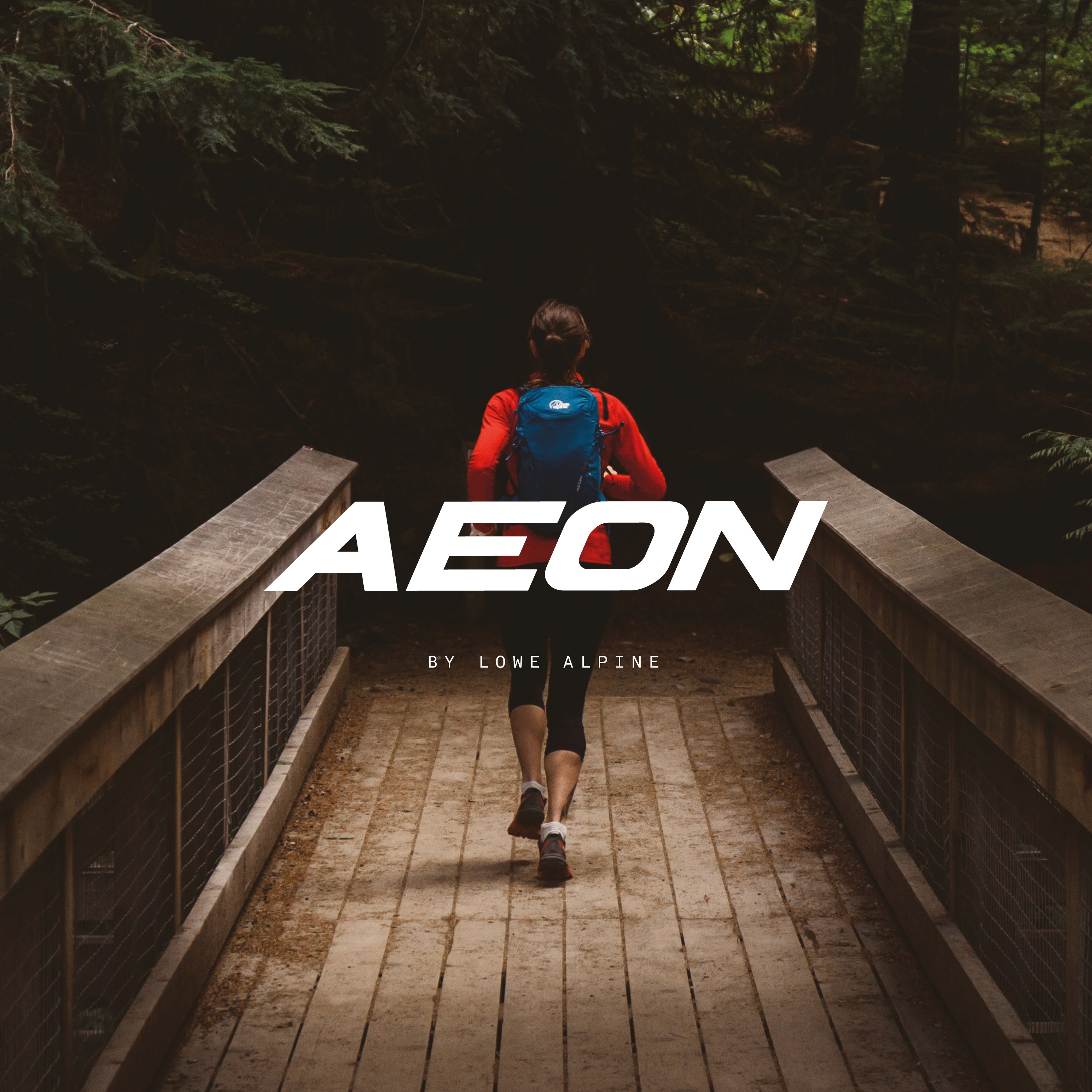 Trail runner wearing Lowe Alpine Aeon backpack crossing a wooden bridge in forest, lightweight technical daypack for running and hiking.