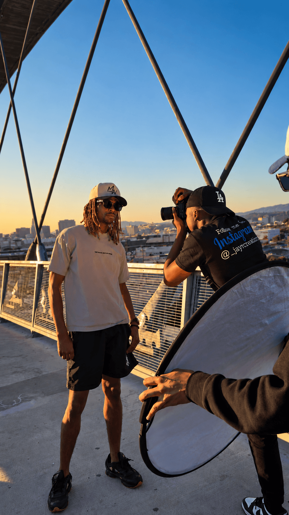 The filmmaker actively filming on a rooftop at golden hour