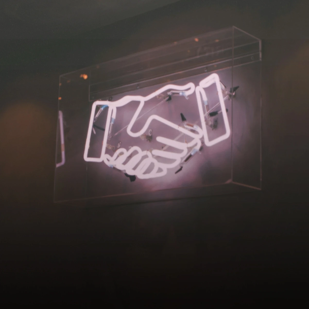 A neon sign of a handshake
