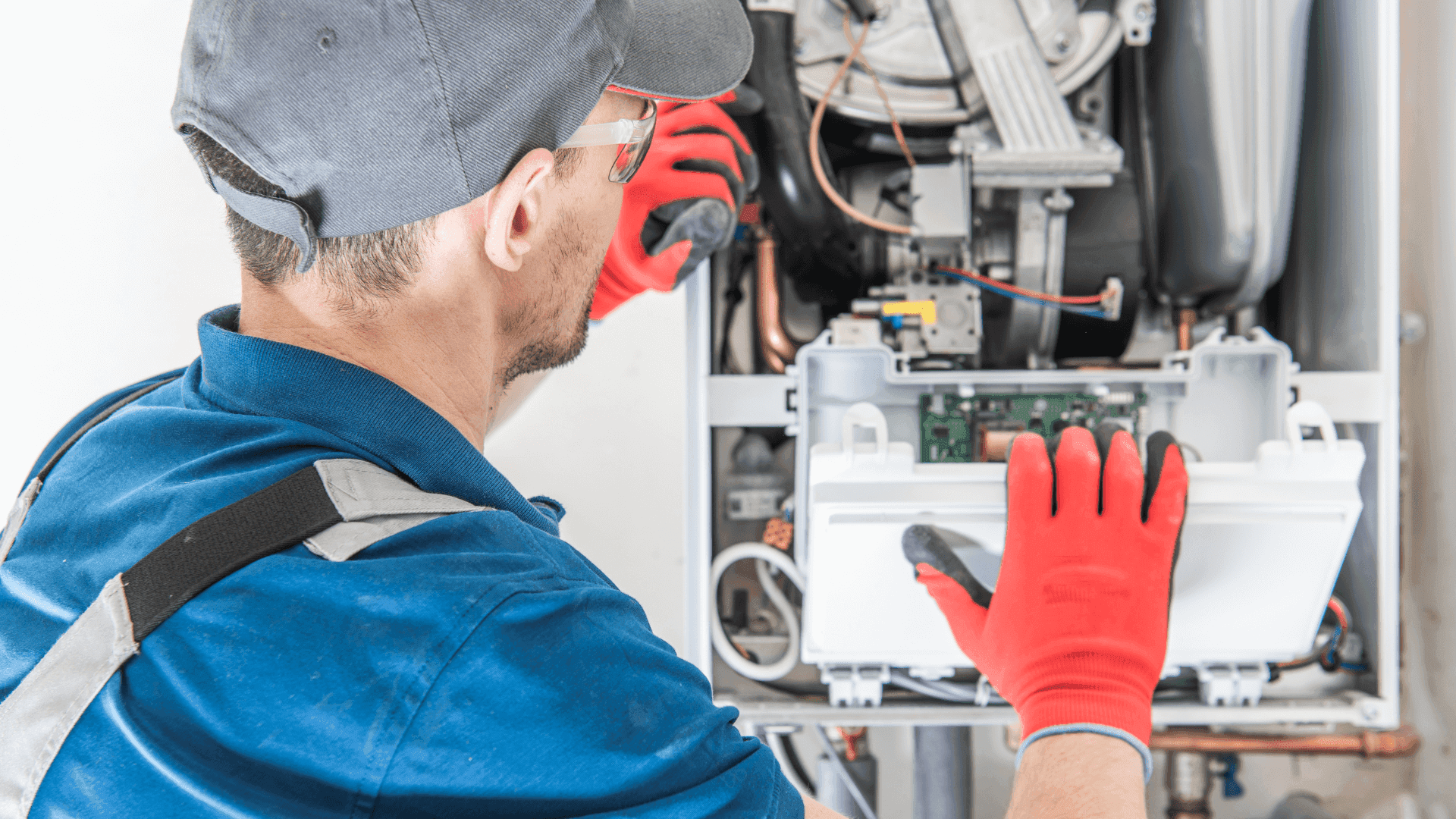 Heizungsmonteur arbeitet an einer alten Gasheizung