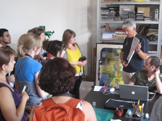 A photo of a person presenting a picture to a group of students.