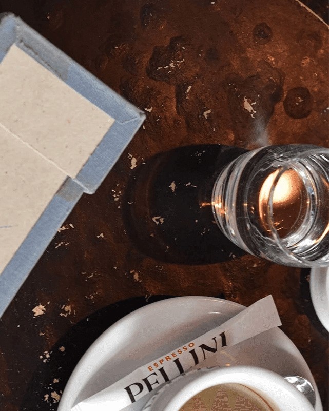 Overhead shot of a coffee table with an espresso cup and a glass of water
