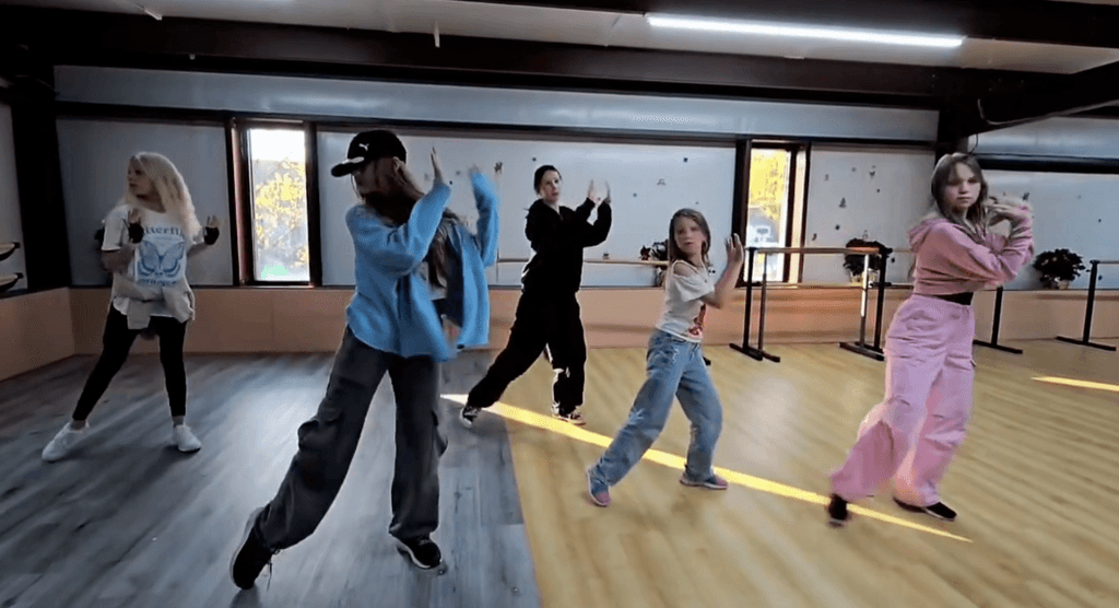 Hip hop class with five students dancing mid-choreography