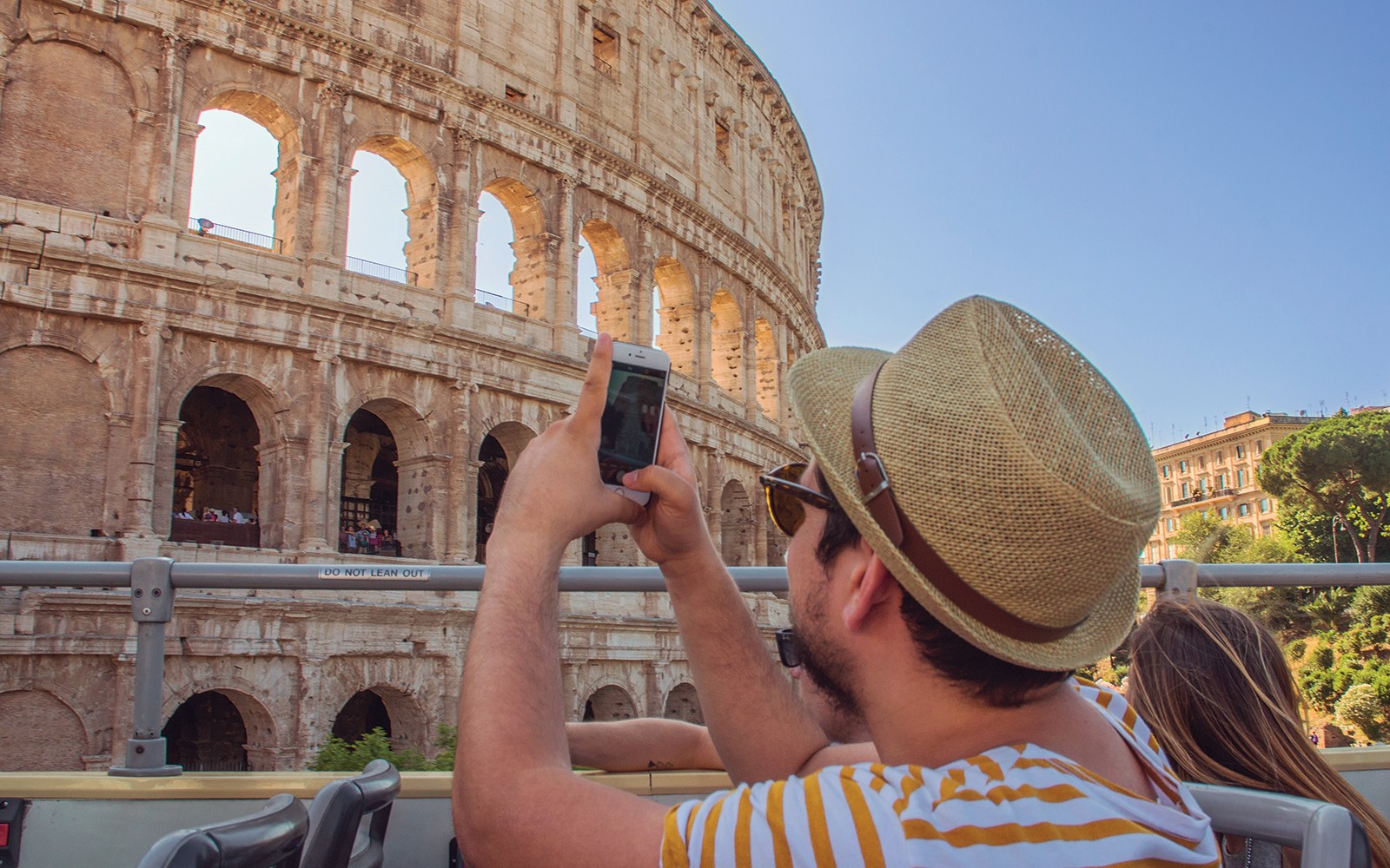 Toeristen op een open-top Big Bus Tours Rome die langs het Colosseum in Rome, Italië rijden.
