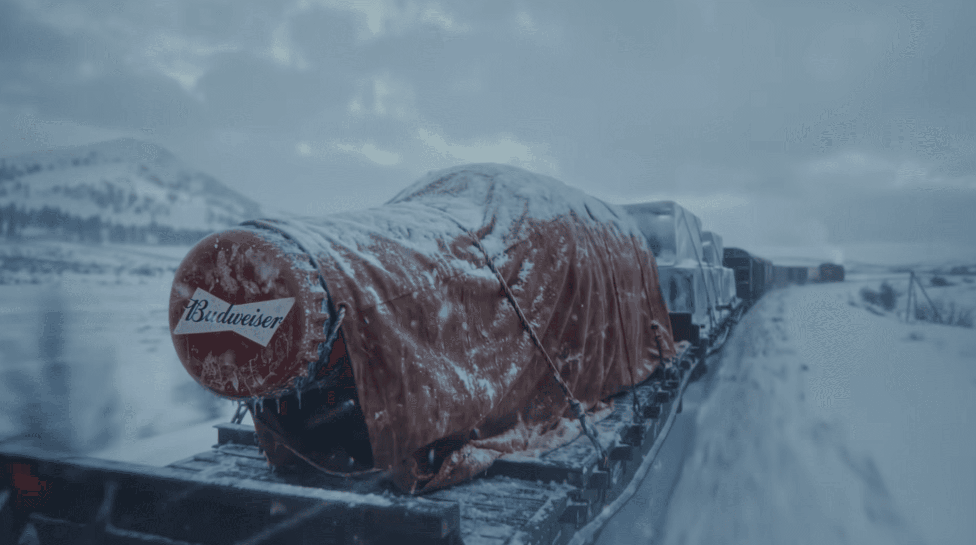 Zugwagon im Winter, auf dem eine große, rote Flasche liegt.