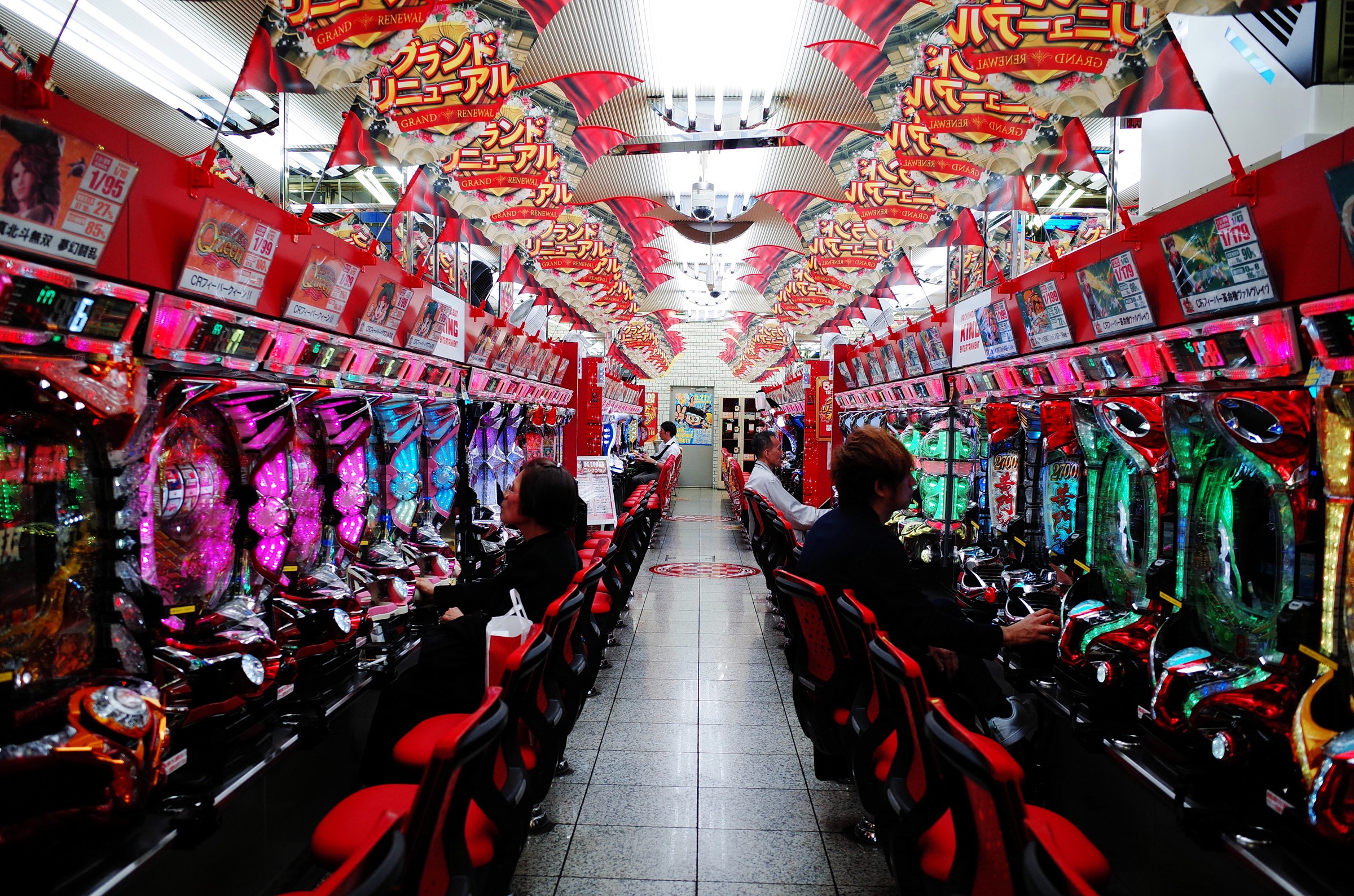 Photographie symmétrique d'une allée de machines de jeu dans un pachinko à Tokyo