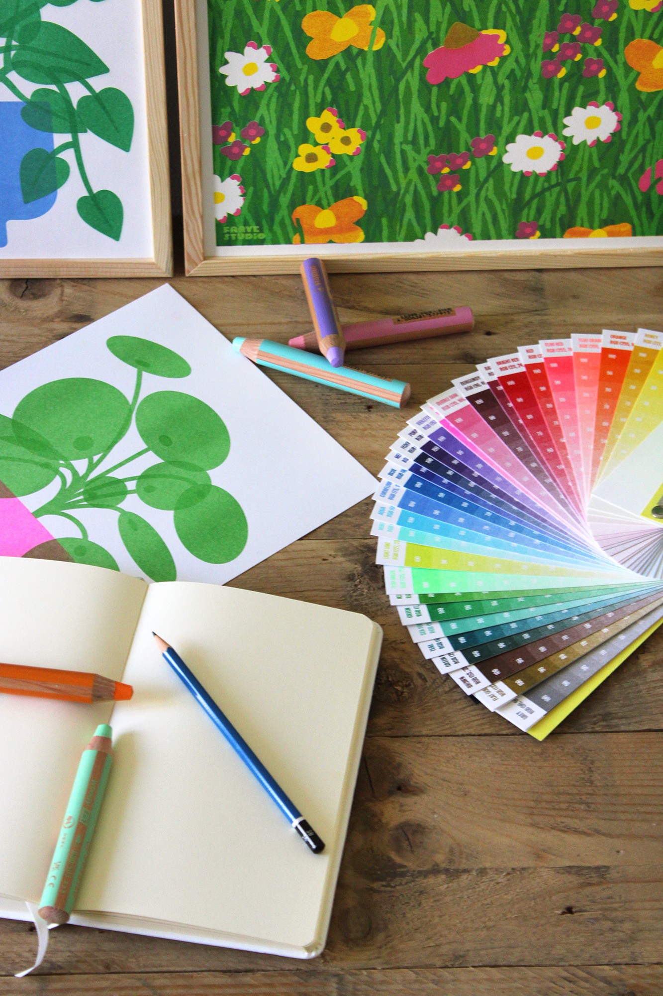 Carnet, crayons et nuancier sur un bureau