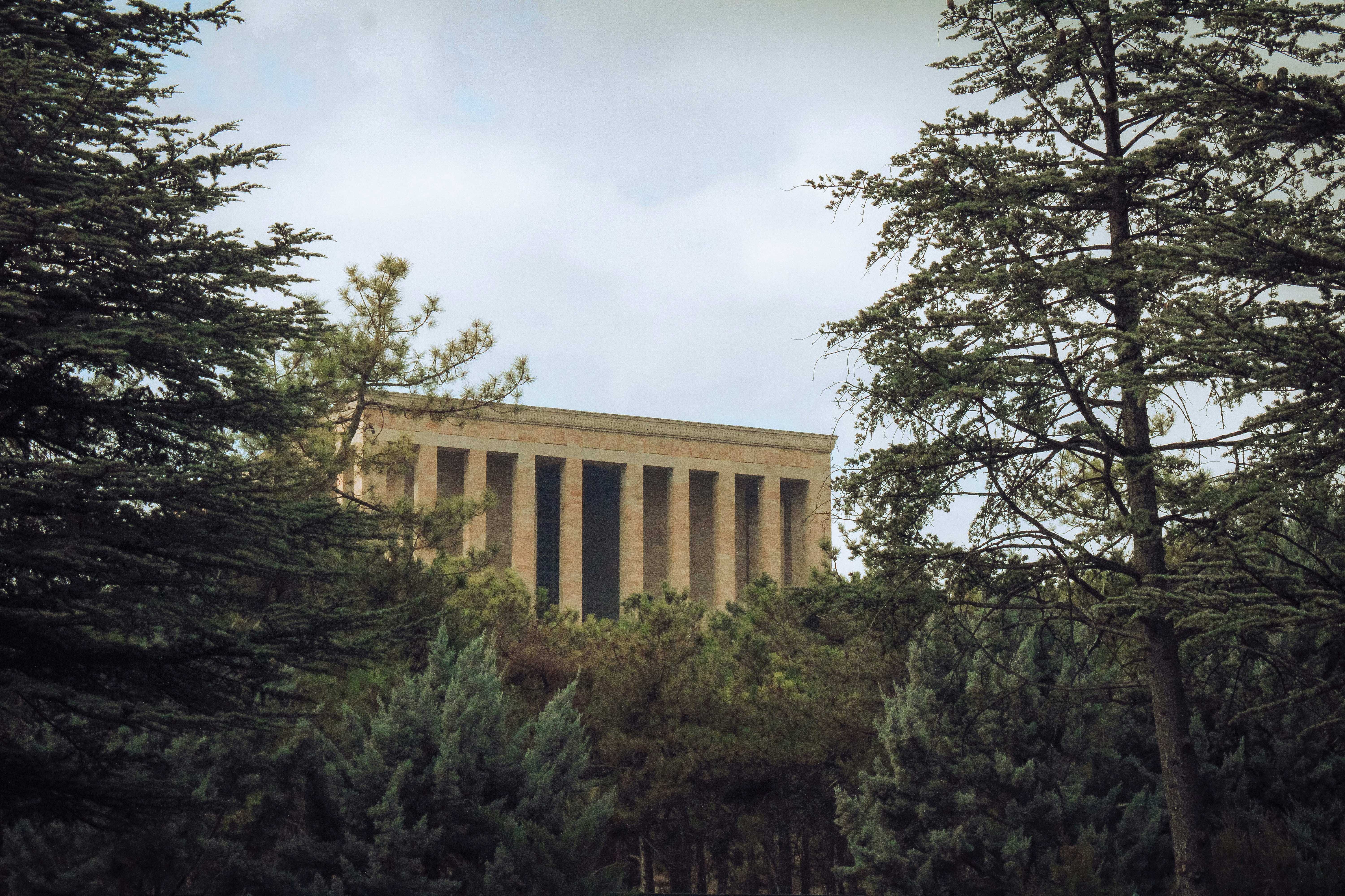 a tall building surrounded by trees on a cloudy day