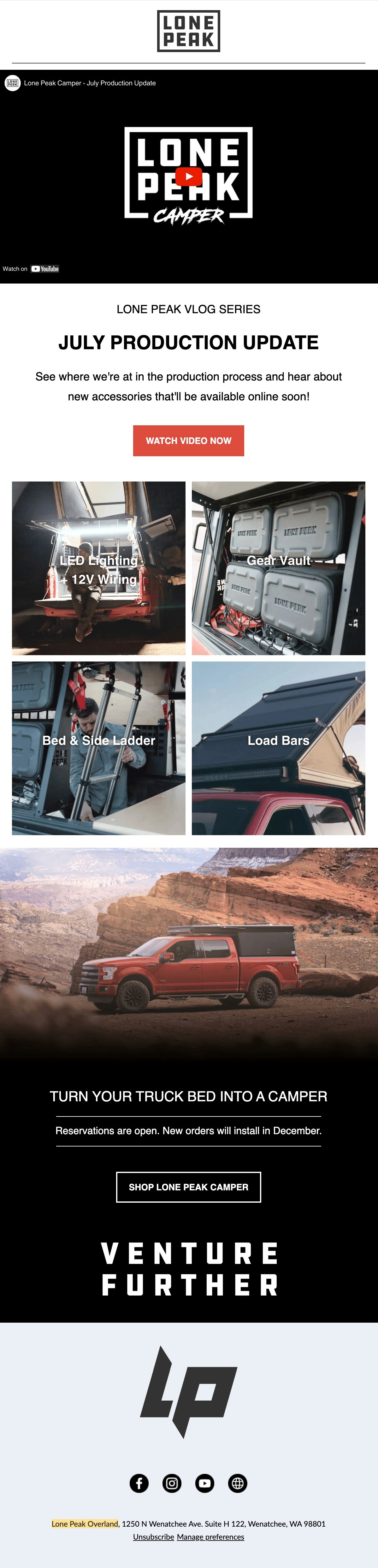 Black and white photo of two people looking at a computer screen with papers on wall