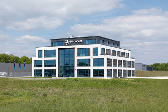 Modernes Bürogebäude mit weißer Fassade und großen Glasflächen, Logo "INconnect" auf dem Dach.