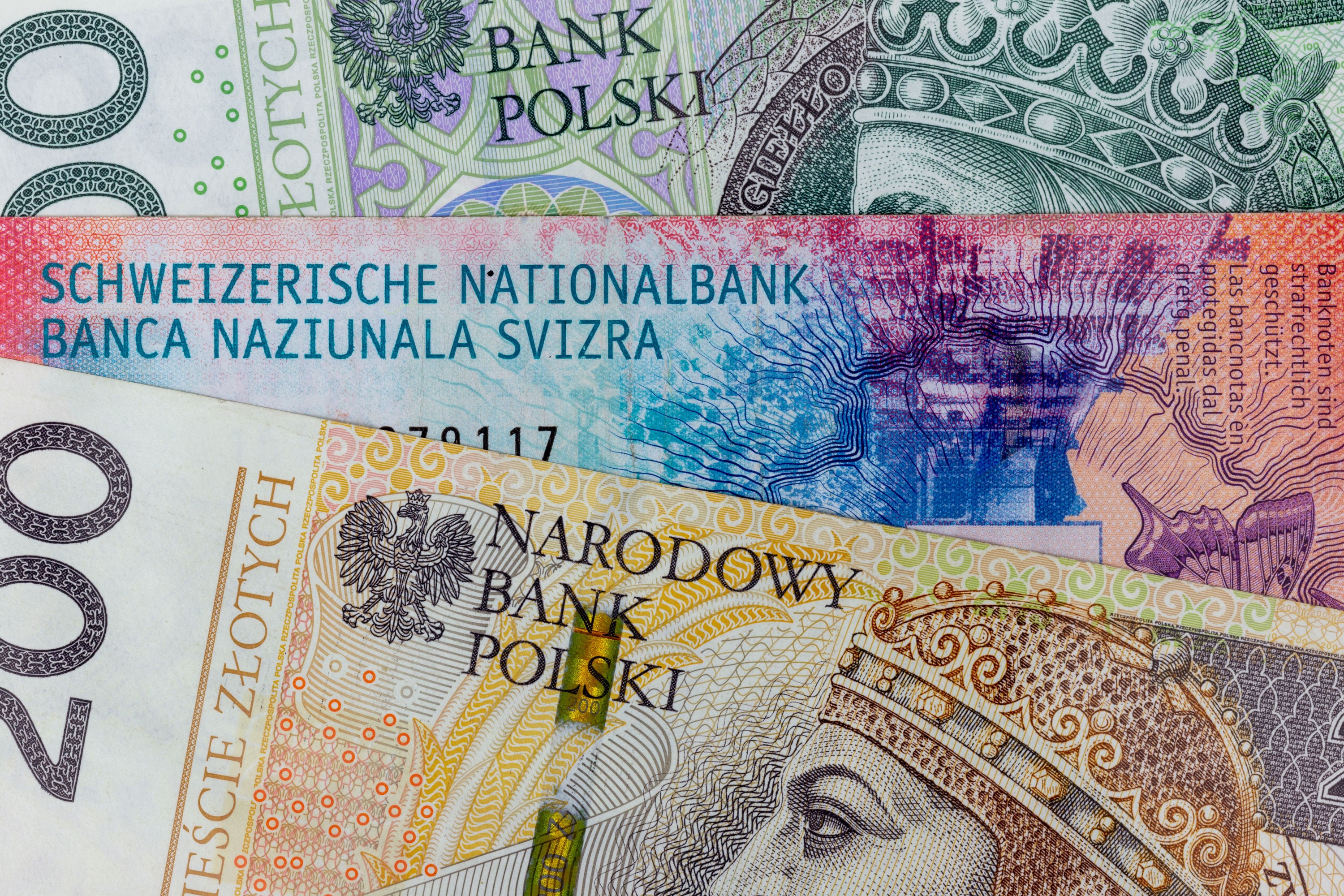 Polish zloty and Swiss franc banknotes displayed together.