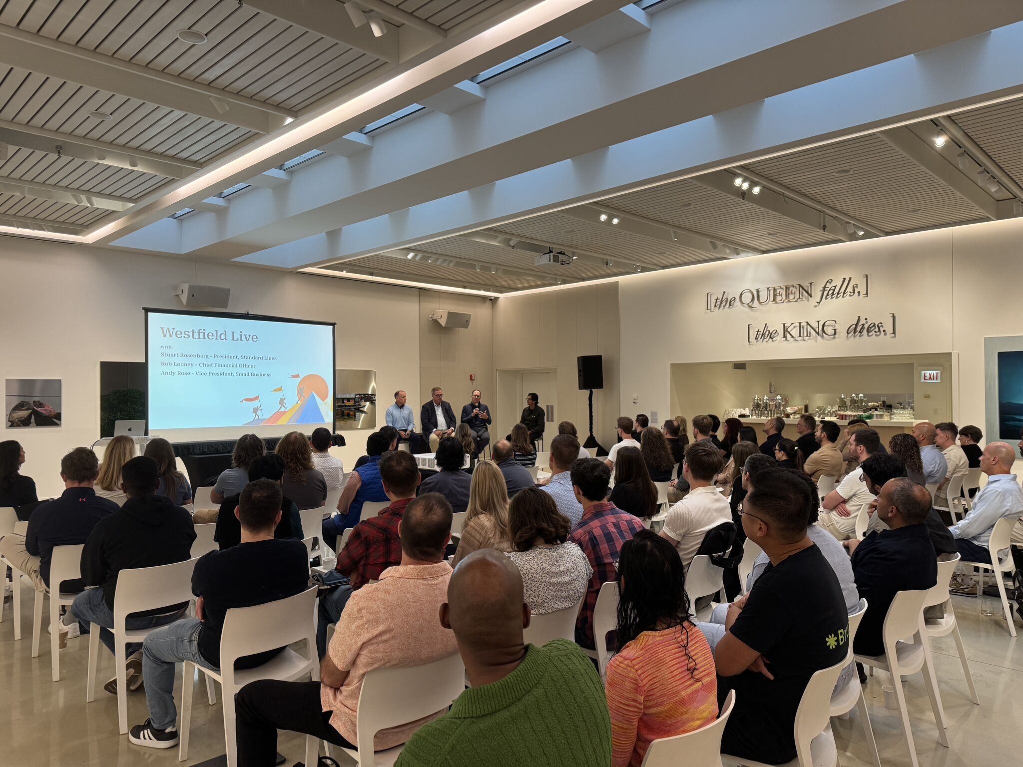 four person hands wrap around shoulders while looking at sunset