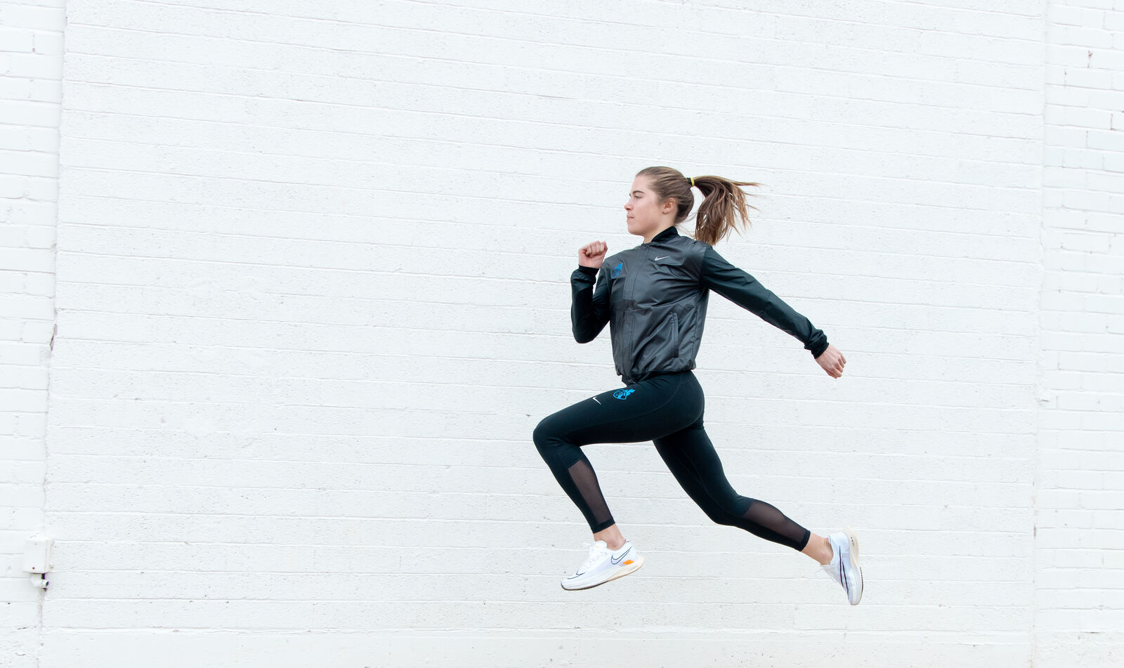 Nike shoot, a runner mid-stride against a pale wall