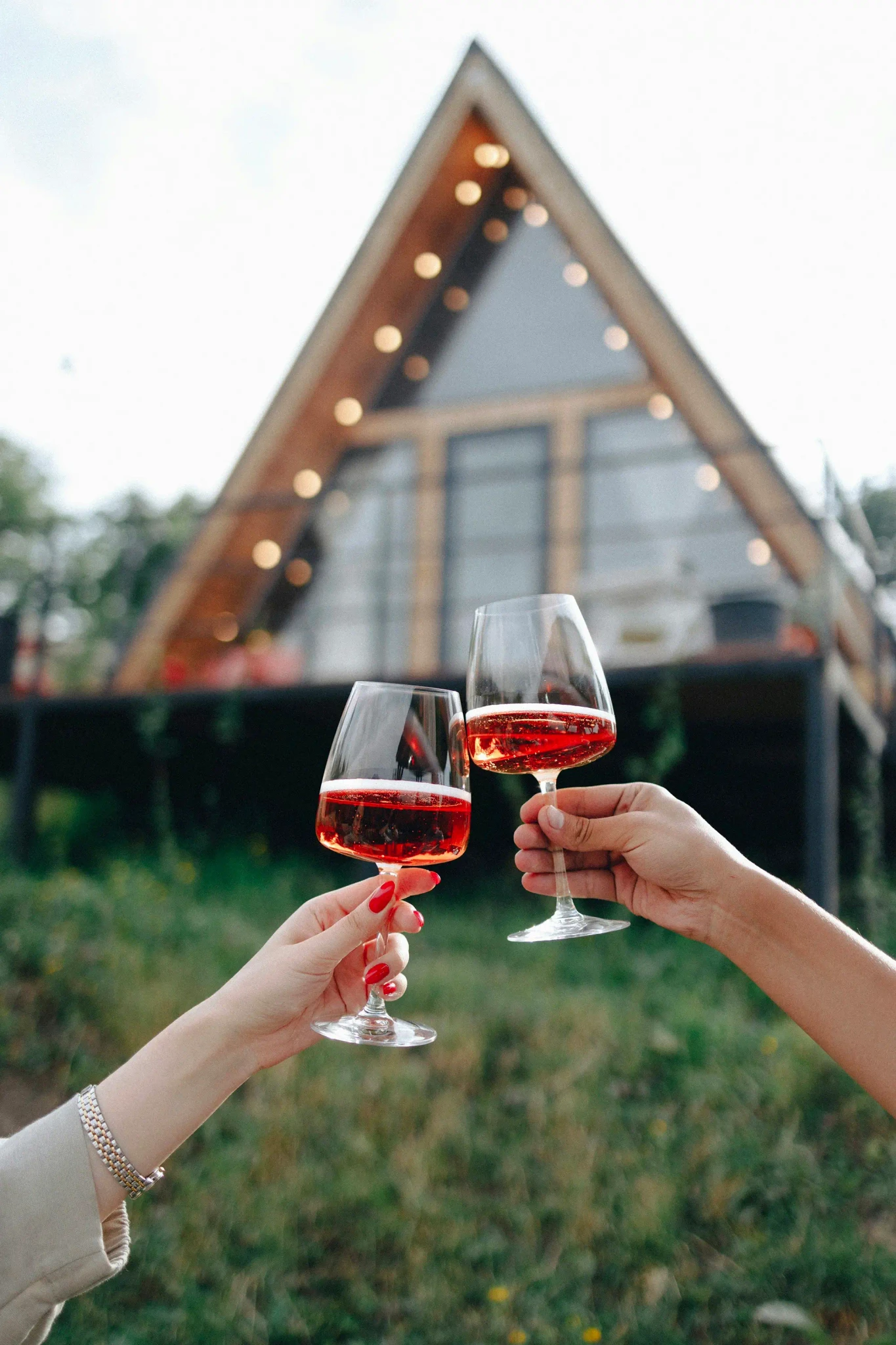 a couple of hands holding wine glasses