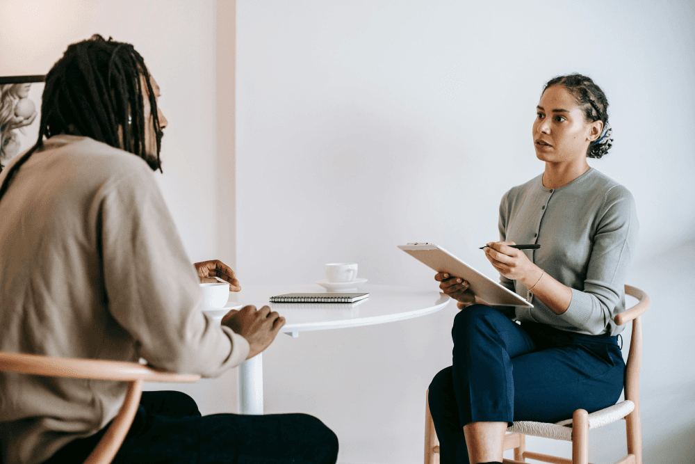 Two professionals in a collaborative meeting, one gesturing as if explaining options, symbolizing the process of finding the right instructional design sector for your career.