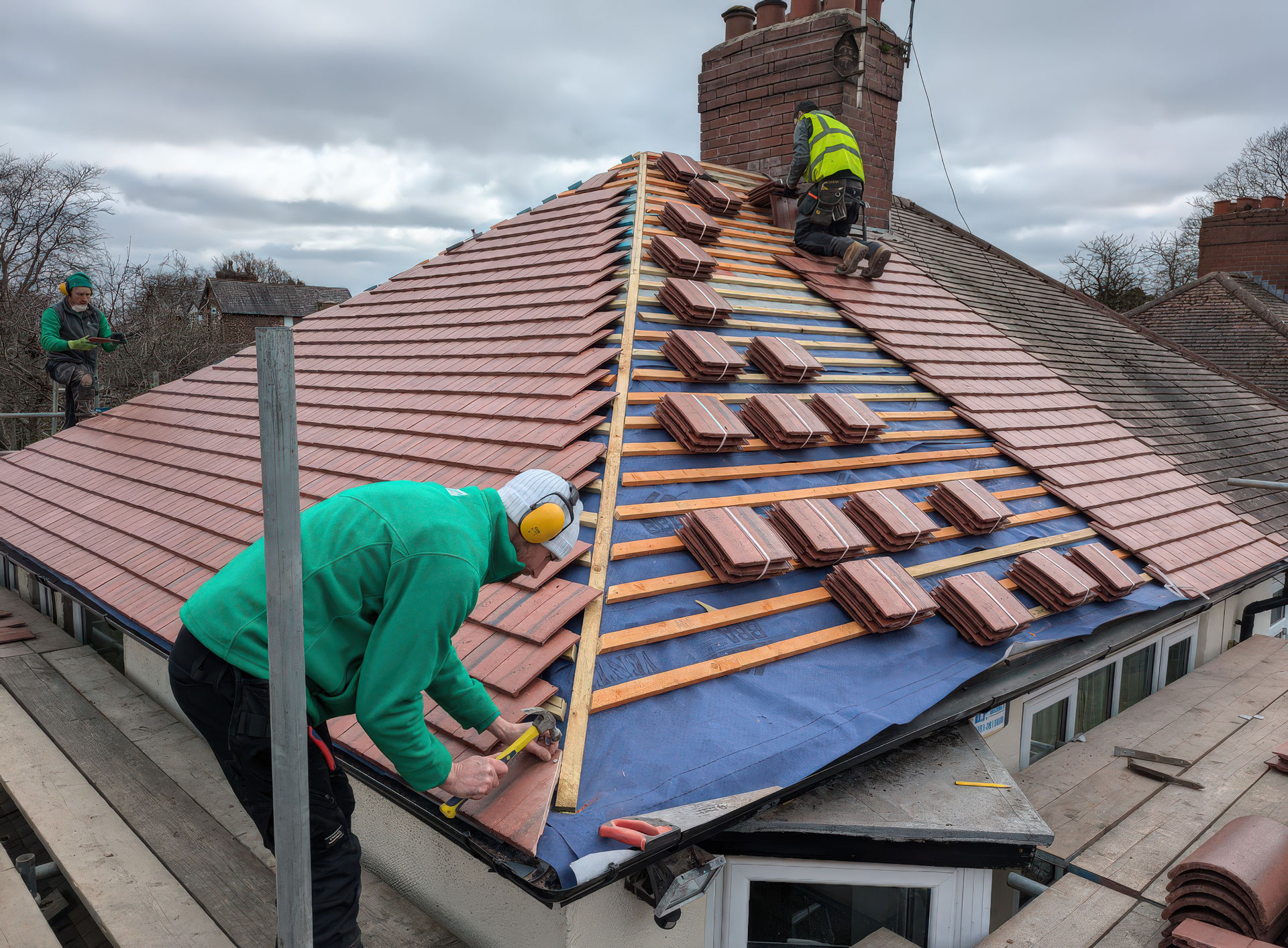 men tiling a roof 