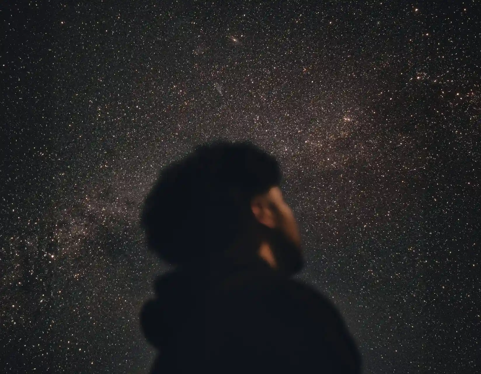 young black man looking up at the starry night sky